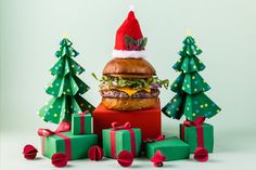 a large hamburger sitting on top of a pile of presents