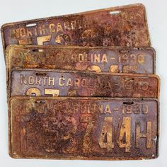 three old rusty license plates sitting on top of each other