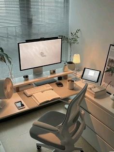 a computer desk with two monitors and a laptop on it in front of a window