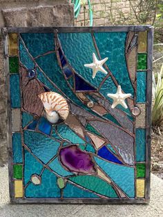 a sea shell and starfish on a stained glass panel