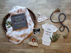 a baby's first birthday outfit and other items laid out on a wooden floor