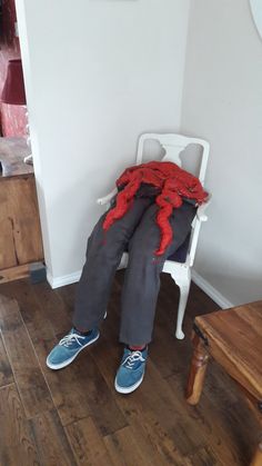 a person sitting in a chair with red yarn on it