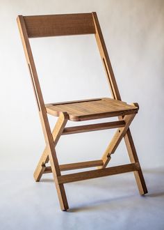 a wooden folding chair on a white background