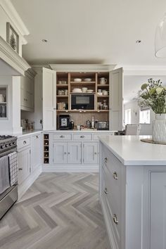 a kitchen with white cabinets and wood flooring