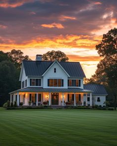 a large white house sitting on top of a lush green grass covered field under a cloudy sky