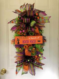 a door decorated with an orange, green and purple halloween deco mesh wreath that says it's just a bunch of hocsies