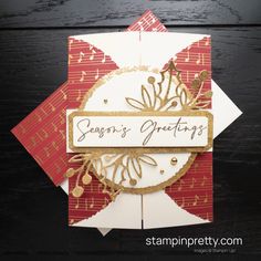 a close up of a card on a wooden surface with the words season's greetings