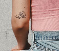 a woman's arm with a lion tattoo on the left side of her body