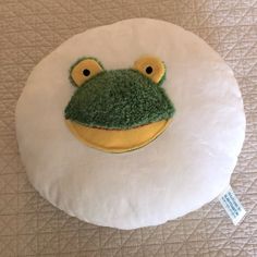 a pillow with a green frog face on it