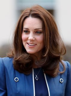 a woman with brown hair wearing a blue suit