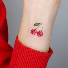 a small cherry tattoo on the wrist