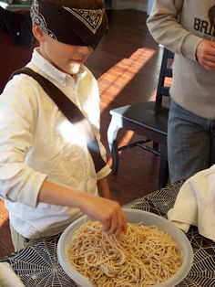 two people standing over a table with some food on it