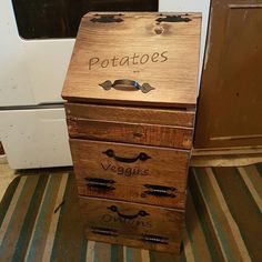 a wooden box with writing on it sitting in front of a stove and microwave oven