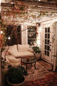 a living room filled with furniture and lots of lights hanging from the ceiling above it