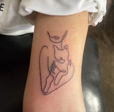 a woman's arm with a tattoo on it that has an image of a cat and a dog