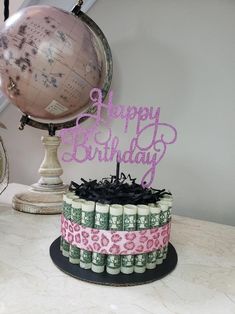 a birthday cake decorated with money and a globe