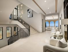 a living room filled with white furniture next to a large open floor plan and windows