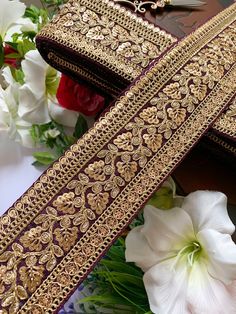 a close up of a cross on a table with flowers and other items in the background