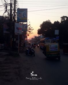 the sun is setting on a busy street with people riding motorcycles and scooters