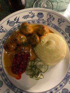 a white plate topped with meatballs covered in gravy