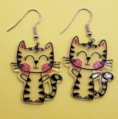 These earrings are so adorable. This cute cat is clear with black stipes and pink cheeks! These earrings are light weight and has the image on both sides. Cute Cat Ears Earrings With Cat Print, Pink Cat Design Earrings With Cat Ears Shape, Fun Black Earrings, Cute Black Cat Design Earrings, Cute Black Hypoallergenic Earrings, Cute Hypoallergenic Black Earrings, Fun Black Hypoallergenic Earrings, Black Hypoallergenic Fun Earrings, Playful Black Earrings For Gift