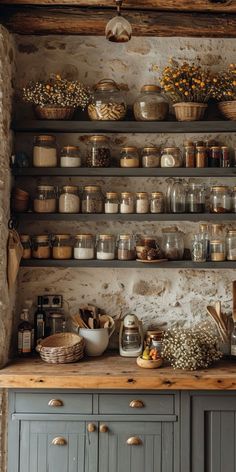 an old kitchen with lots of pots and pans on the shelves, including flowers