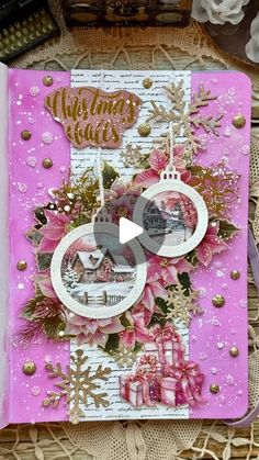 a pink and white christmas card with gold trimmings on the edge, surrounded by other decorations