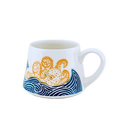 a coffee cup with an octopus on it's side and waves in the background