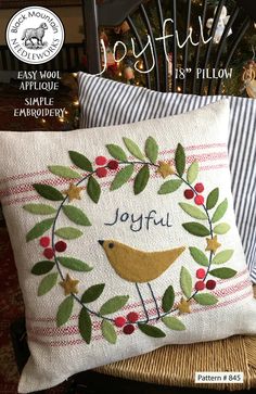 two pillows on a chair in front of a christmas tree with the words joyful