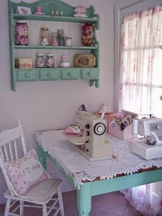 a sewing machine sitting on top of a table next to a white chair and window