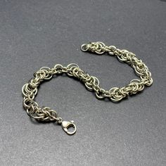 Do you have a hidden inner strength? Why not let it show with some beautiful chainmail jewellery?  This is a beautiful chainmail bracelet, in a Byzantine 'Flare' weave. An ornate and beautiful bracelet that's lightweight and easy to wear.  It's handcrafted, ring by ring in sparkling, stainless steel and is 20.5cm in length, including it's stainless steel lobster clasp.  My handcrafted chainmail creations are made with quality materials from quality suppliers, resulting in beautiful pieces that l Metal Box Chain Bracelet, Metal Chain Link Bracelet For Jewelry Making, Stainless Steel Chainmail Bracelet As Gift, Adjustable Chainmail Chain Bracelet As A Gift, Chainmail Bracelet For Jewelry Making, Adjustable Chainmail Chain Bracelet, Handmade Medieval Metal Bracelets, Round Chainmail Metal Jewelry, Round Metal Chainmail Jewelry