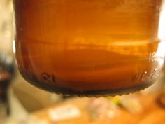 a close up view of a brown jar hanging from a hook on a wooden table