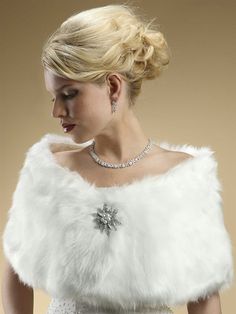 a woman in a wedding dress wearing a white fur stole with crystal brooches