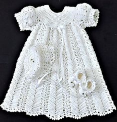 a white crochet baby dress and shoes