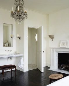 a living room with a fireplace and chandelier