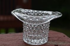 a clear glass vase sitting on top of a wooden table next to a park bench