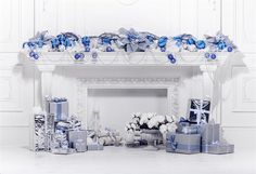 the fireplace is decorated with blue and white flowers, wrapped presents and gifts for someone special occasion