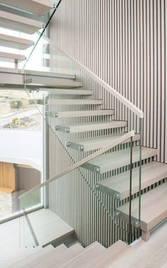 a staircase with glass railing and handrails