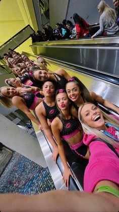 the girls are posing on an escalator in their pink and black bathing suits