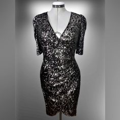 This Is A Brand New With Tags, Calvin Klein Sequined Evening/Party/Special Occasion Dress. The Bodice Crosses Overright Over Leftculminating At The Left Side In Gathers Which Fall Back Into Soft Folds Of A Left To Right Tulip Hem. The Sequins Are Sewn On To A Black Fabric. The Sequins Are Of A Metallic Gunmetal Color On One Side, And A Silvery Metallic Color On The Reverse. Ladies Size 10. Fitted V-neck Sequin Dress For Festive Occasions, Metallic Sequin Holiday Dress With Shimmer, Metallic Sequin Shimmer Dress For Holidays, Metallic Shimmer Sequin Dress For Holidays, Metallic Shimmer Sequin Holiday Dress, Fitted Shimmer Dress For Festive Season, Glamorous Festive Evening Dress For Party Season, Glamorous Evening Dress For Festive Party Season, Fitted Sequin Dress With Shimmer For Festive Occasions