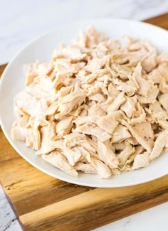 a white plate topped with shredded chicken on top of a table