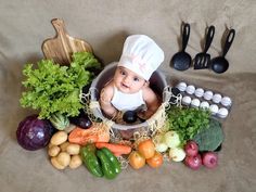 a baby in a chef's hat surrounded by vegetables