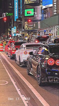 many cars are lined up on the side of the road in front of tall buildings