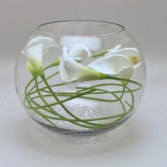 there is a glass vase with white flowers in it