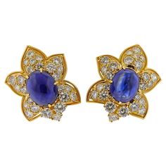 Pair of 18k yellow gold earrings, each set with approx. 8 carat sapphire cabochons, surrounded with approx. 5.00ctw in diamonds. Earrings measure 28mm x 25mm. Weigh 22.1 grams. SKU#E-02726 Luxury Gold Diamond Cabochons, Diamond Gold Earrings, Sapphire Cabochon, Diamonds Earrings, Yellow Gold Earrings, Flower Tops, Diamond Gold, Yellow Gold Earring, Lovely Jewellery