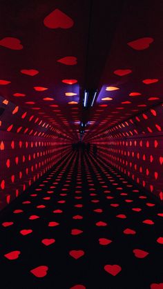 a long tunnel with red and black dots on the walls, as if it were an art installation