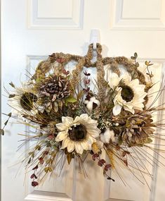 a wreath with dried flowers hanging on the front door