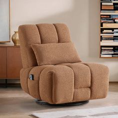 a brown recliner chair sitting on top of a wooden floor next to a book shelf