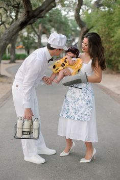 a man and woman holding a baby in their arms