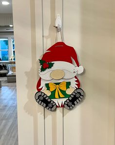 a christmas decoration hanging from the side of a door with santa clause hat on it